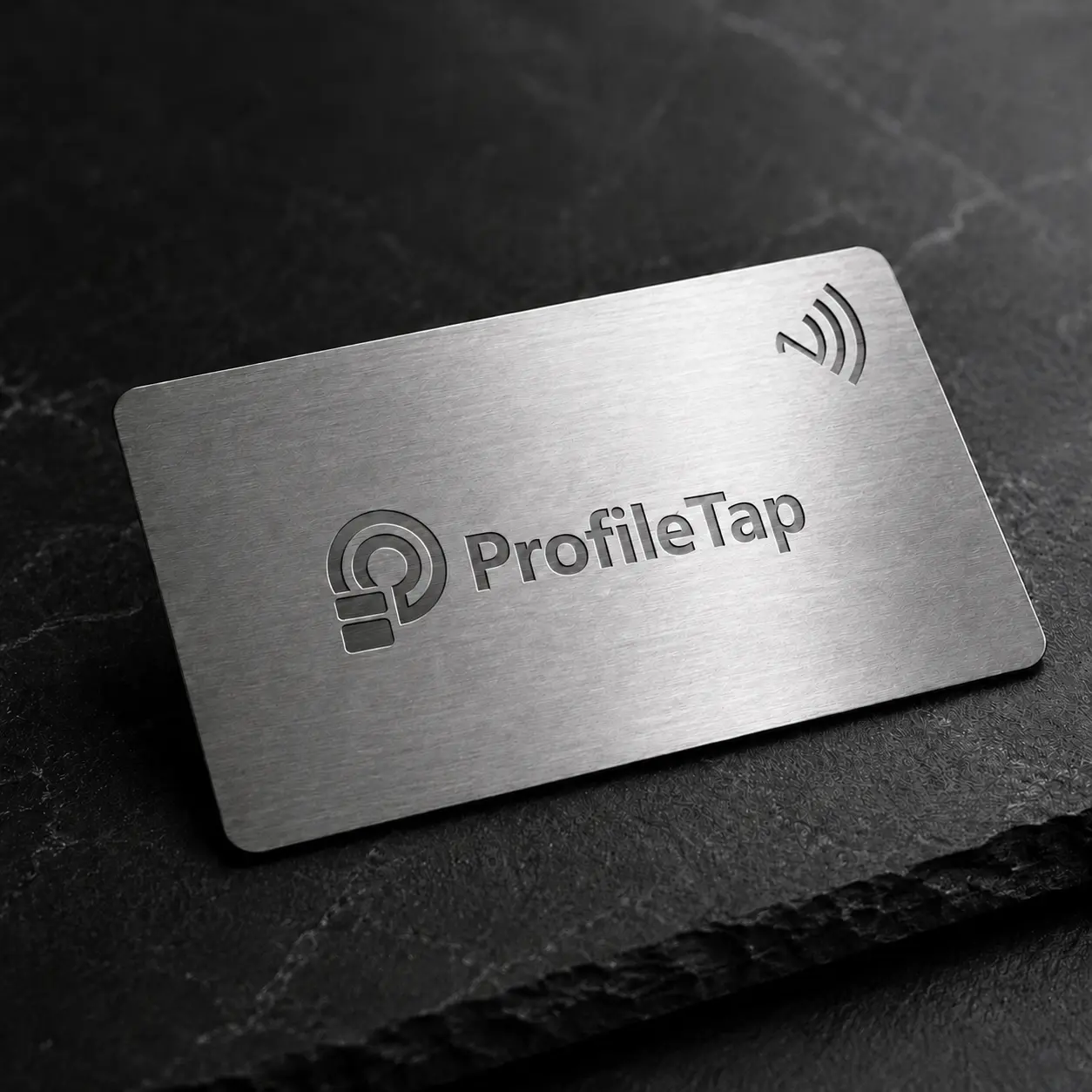 A ProfileTap metal NFC business card in brushed stainless steel, held in hand