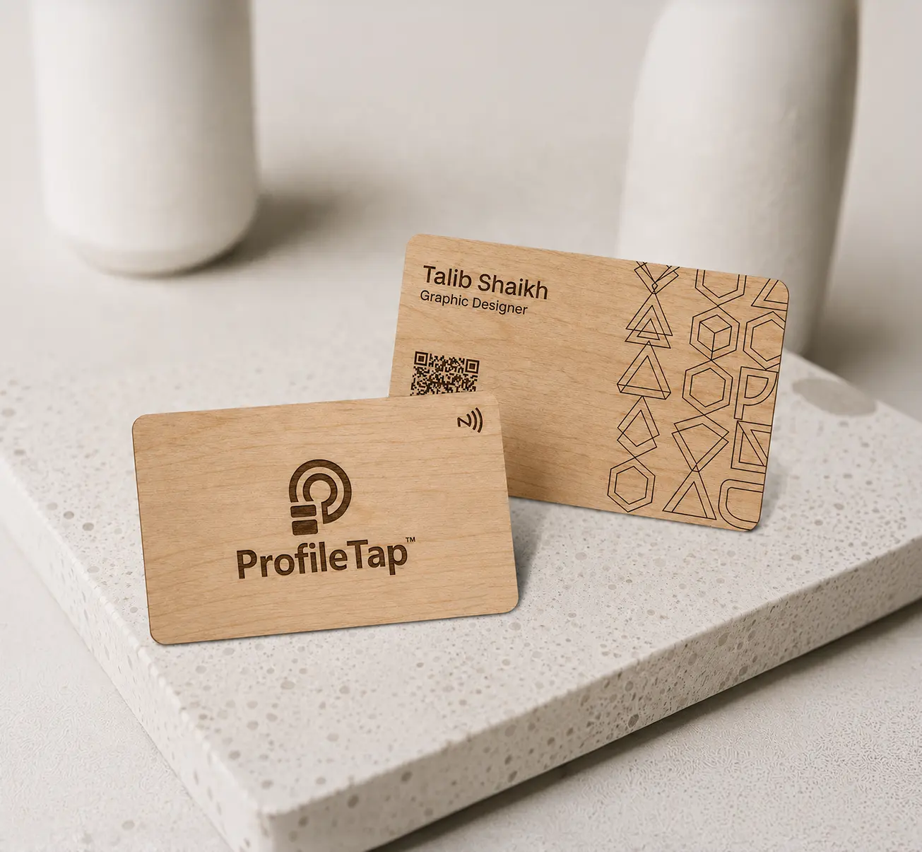 A ProfileTap wooden NFC business card with natural wood grain, held in hand.